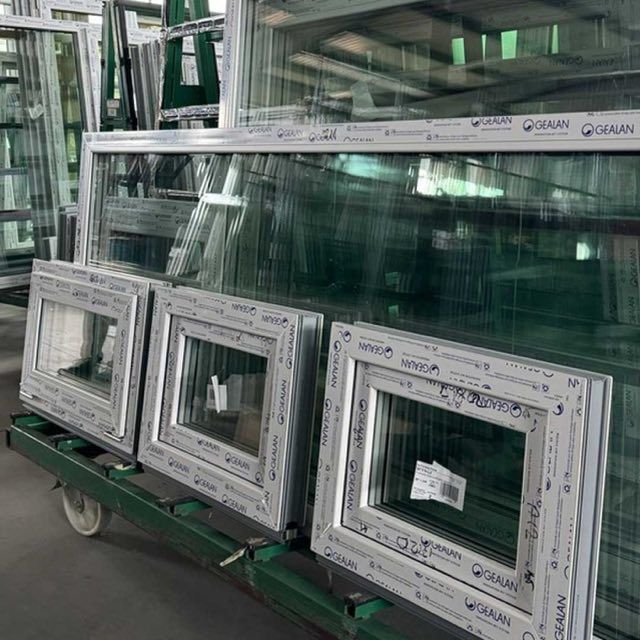 Balti PVC logu rāmji un stikla paketes ratiņos ražotnes noliktavā